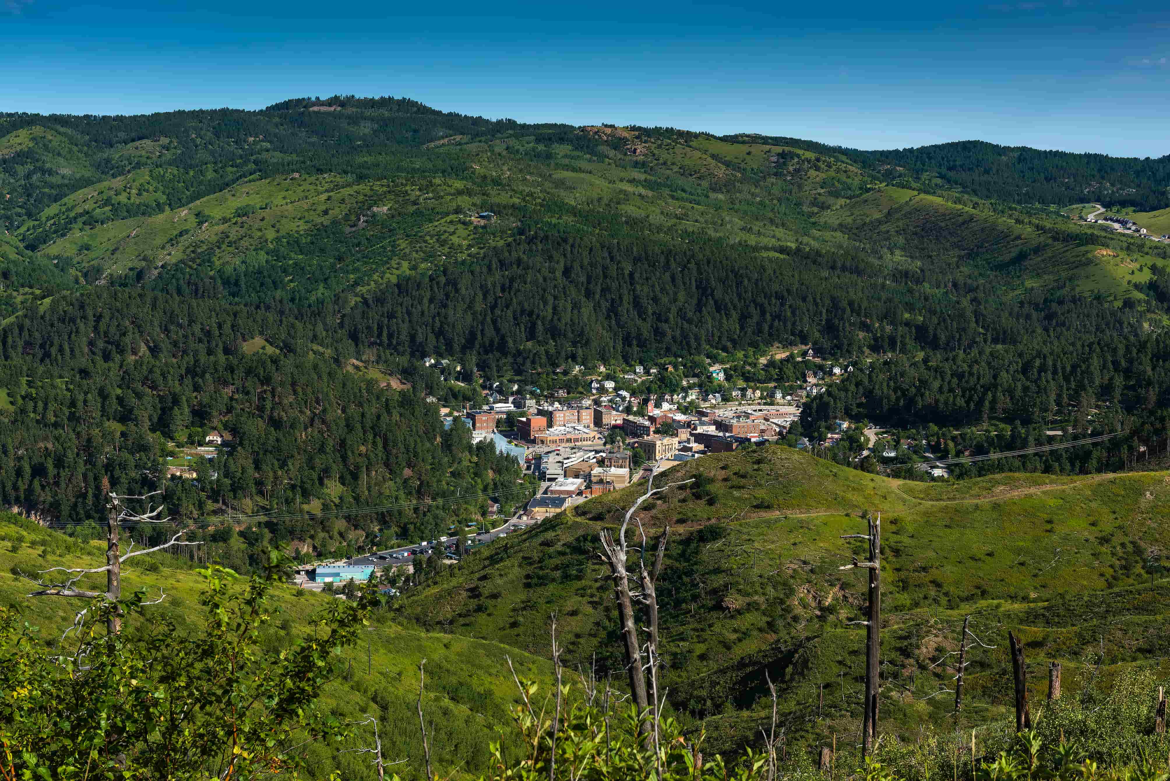 A view of Deadwood and the surrounding green Black Hills forest from the sky
