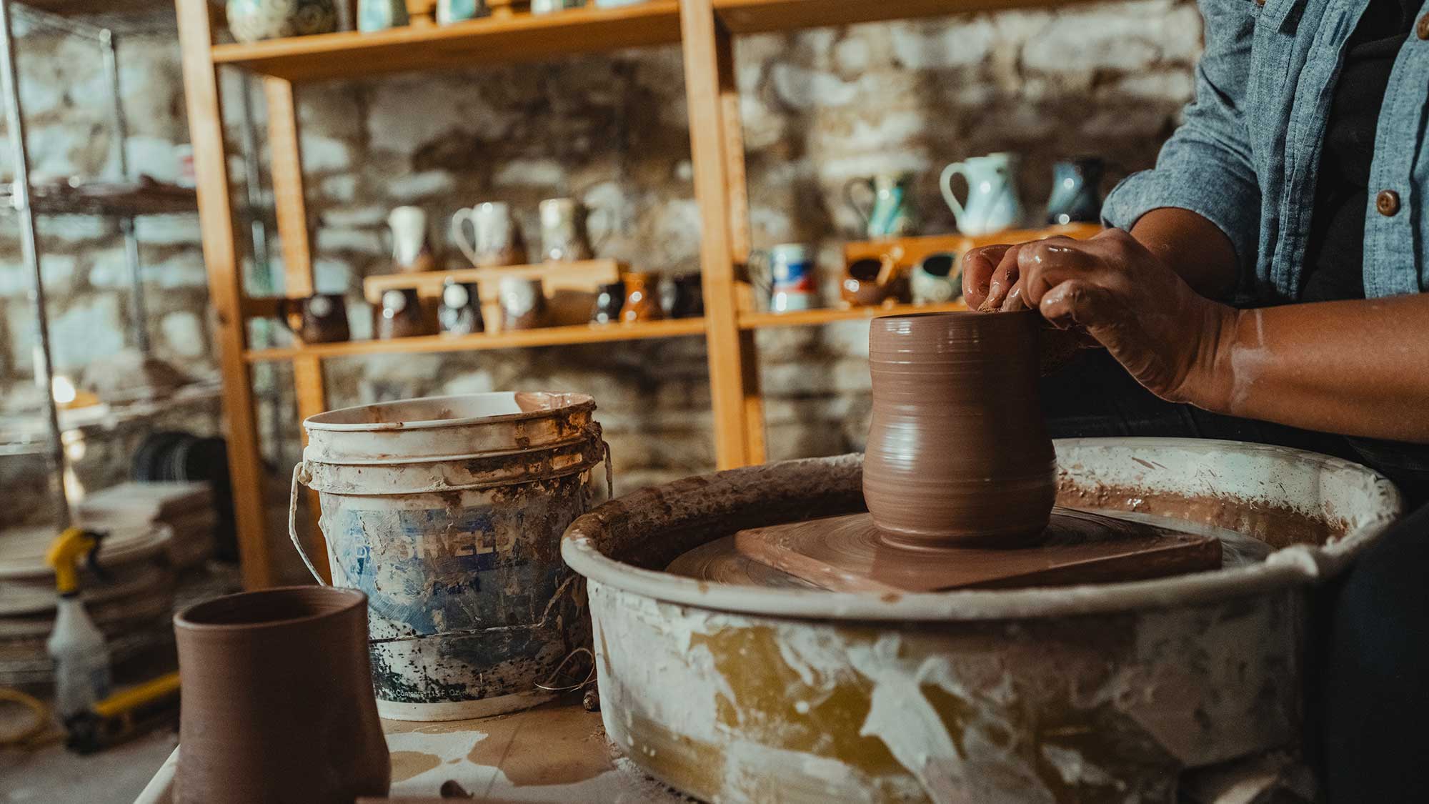 A pair of hands form a vase at Sonja Gloria Pottery in Sioux Falls, SD.