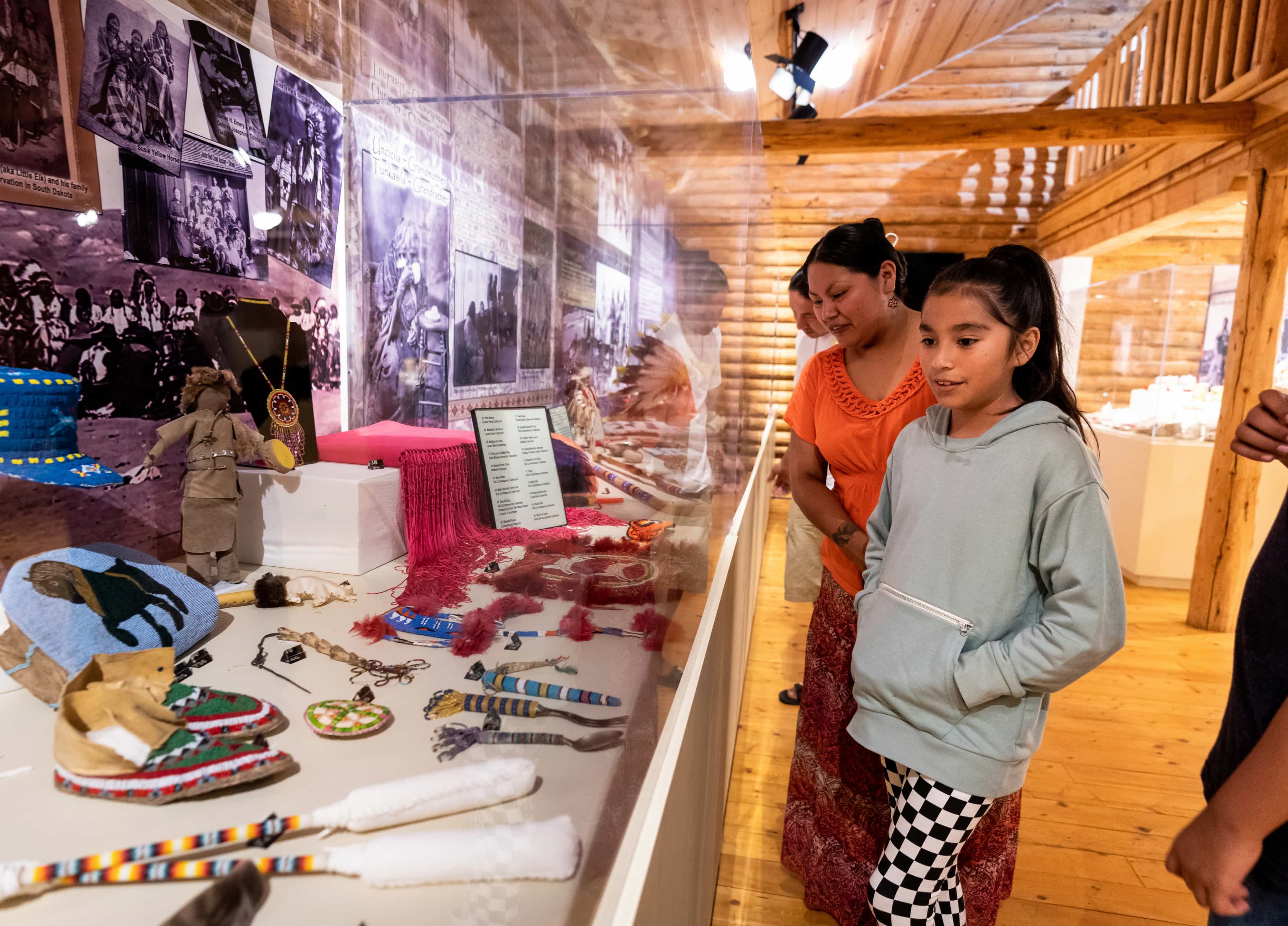 Two people look upon a collection of Native American crafts