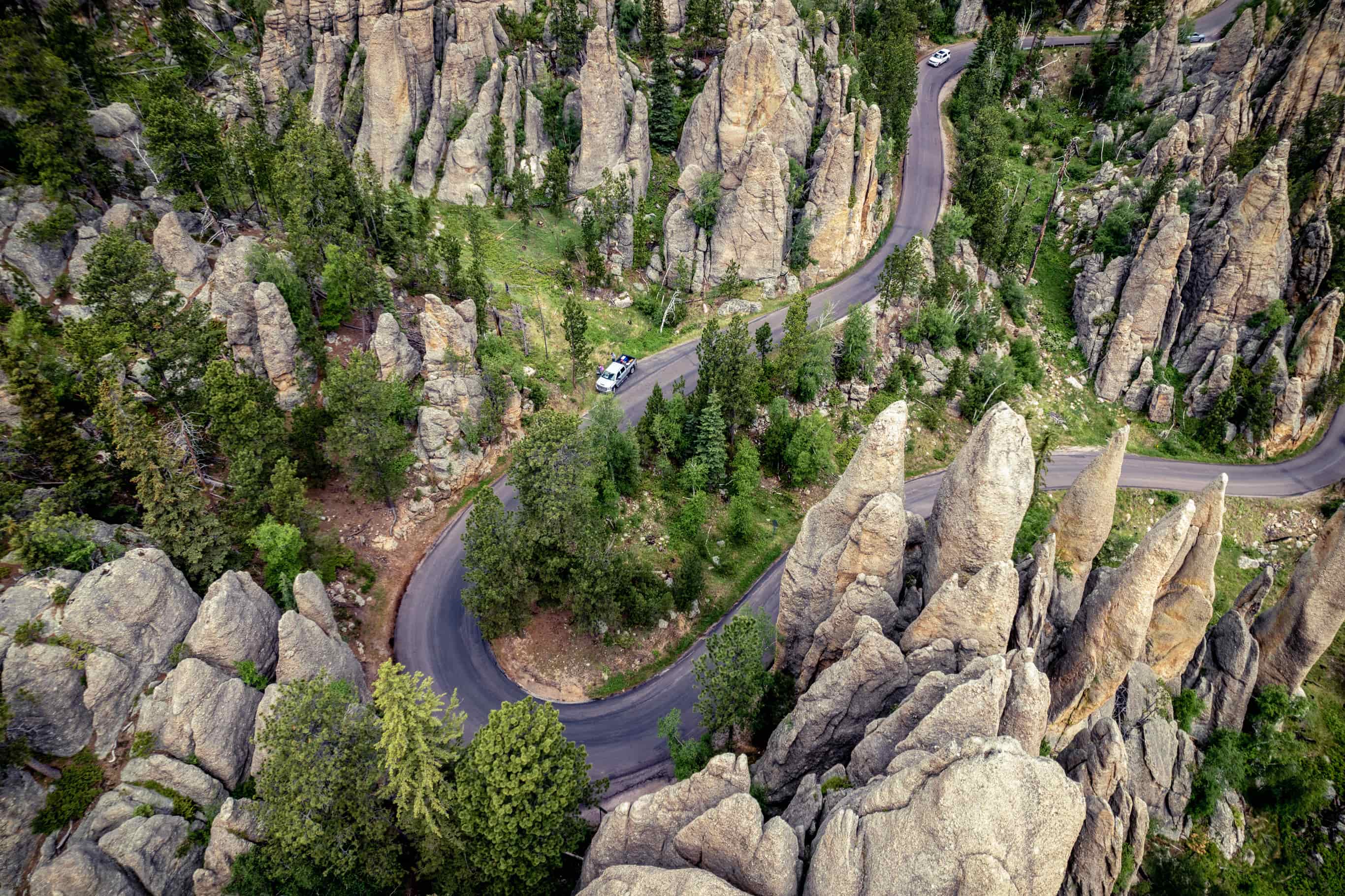 Aerial drone view of Needles Highway in Custer State Park reveals how much the road bends as it winds through the rock formations and granite spires.