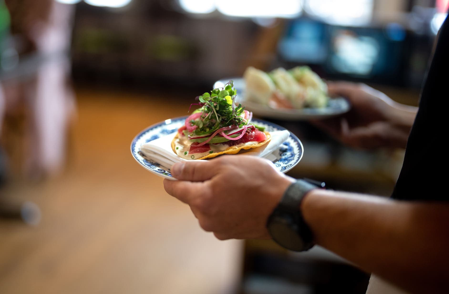 Waiter carrying small plates to table at Skogen Kitchen in Custer, South Dakota.