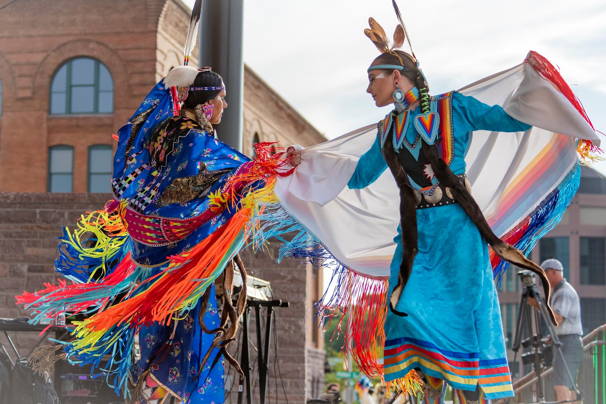 Two women in traditional regalia perform at a wacipi (powwow) in South Dakota.