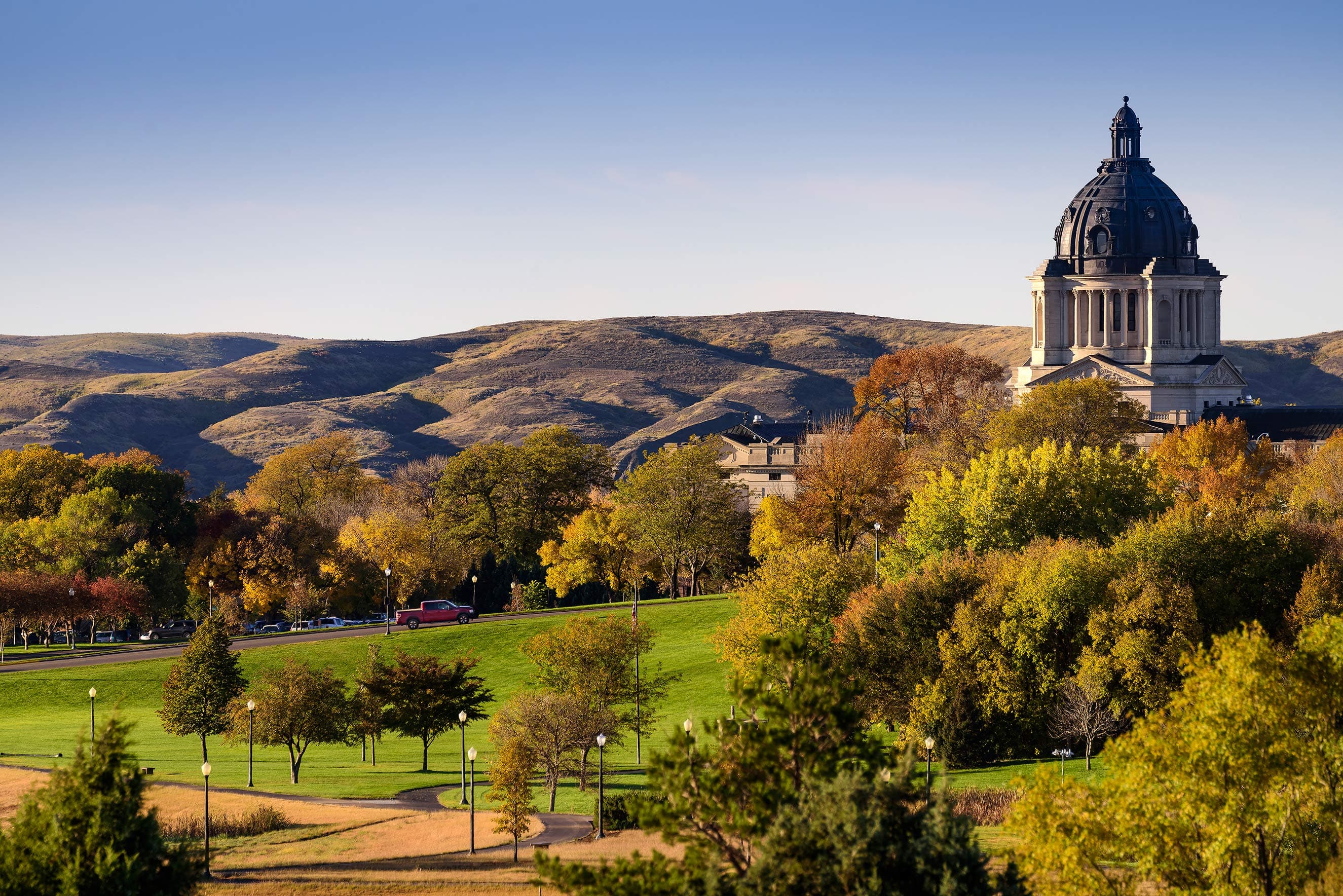 The South Dakota State Capitol in Pierre is pictured amid colorful autumn leaves.