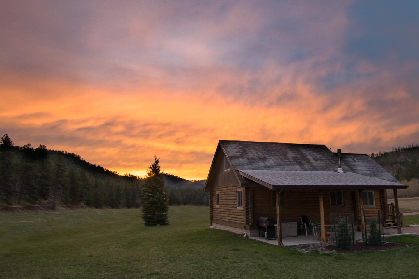 A rustic log cabin in South Dakota, pictured at sunset