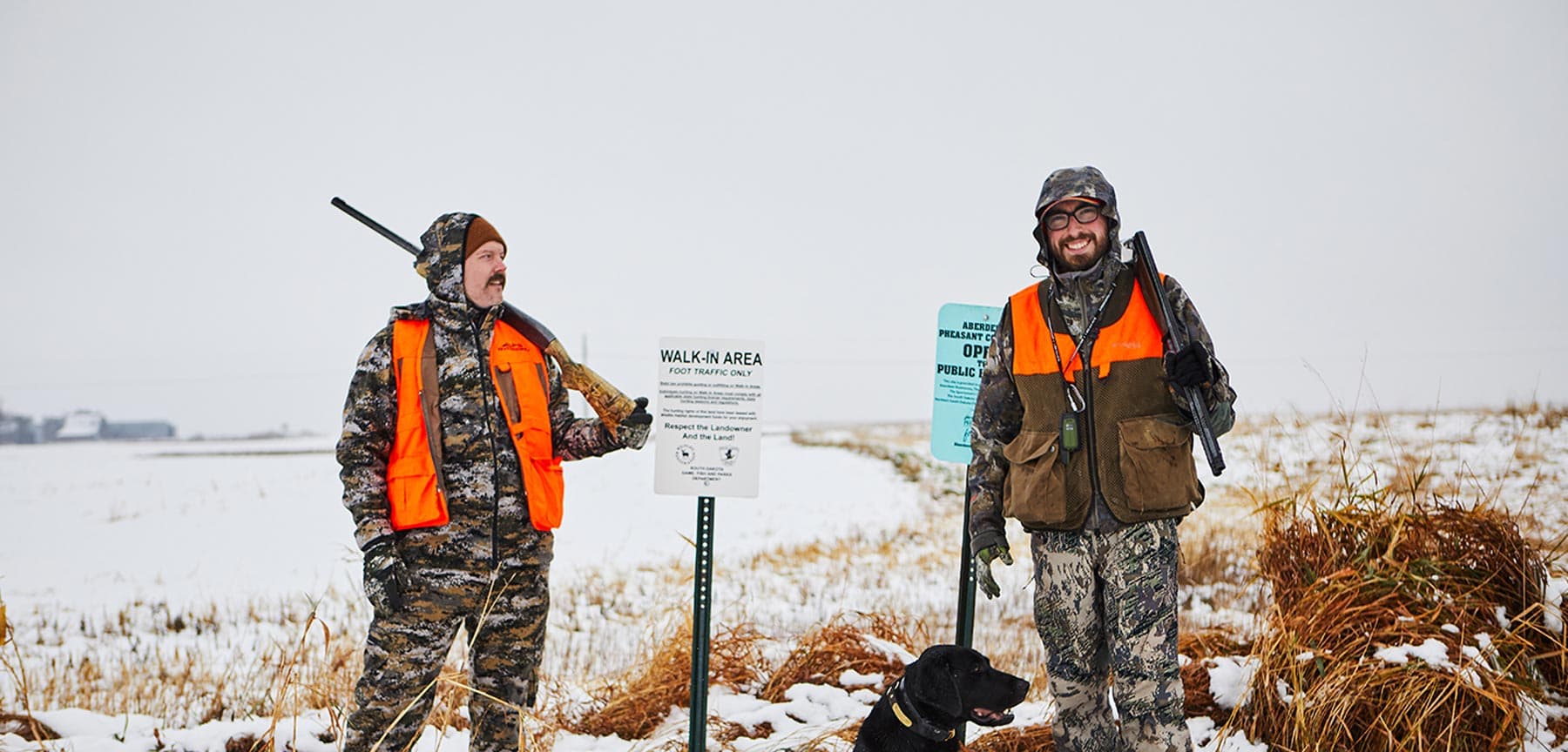 Two pheasant hunters in a snow covered field
