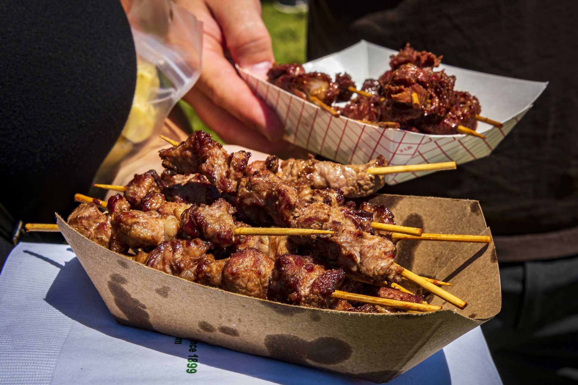 Close up of two containers of chislic, a South Dakota culinary specialty consisting of chunks of meat on skewers. South Dakota Chislic Festival, Freeman, SD.