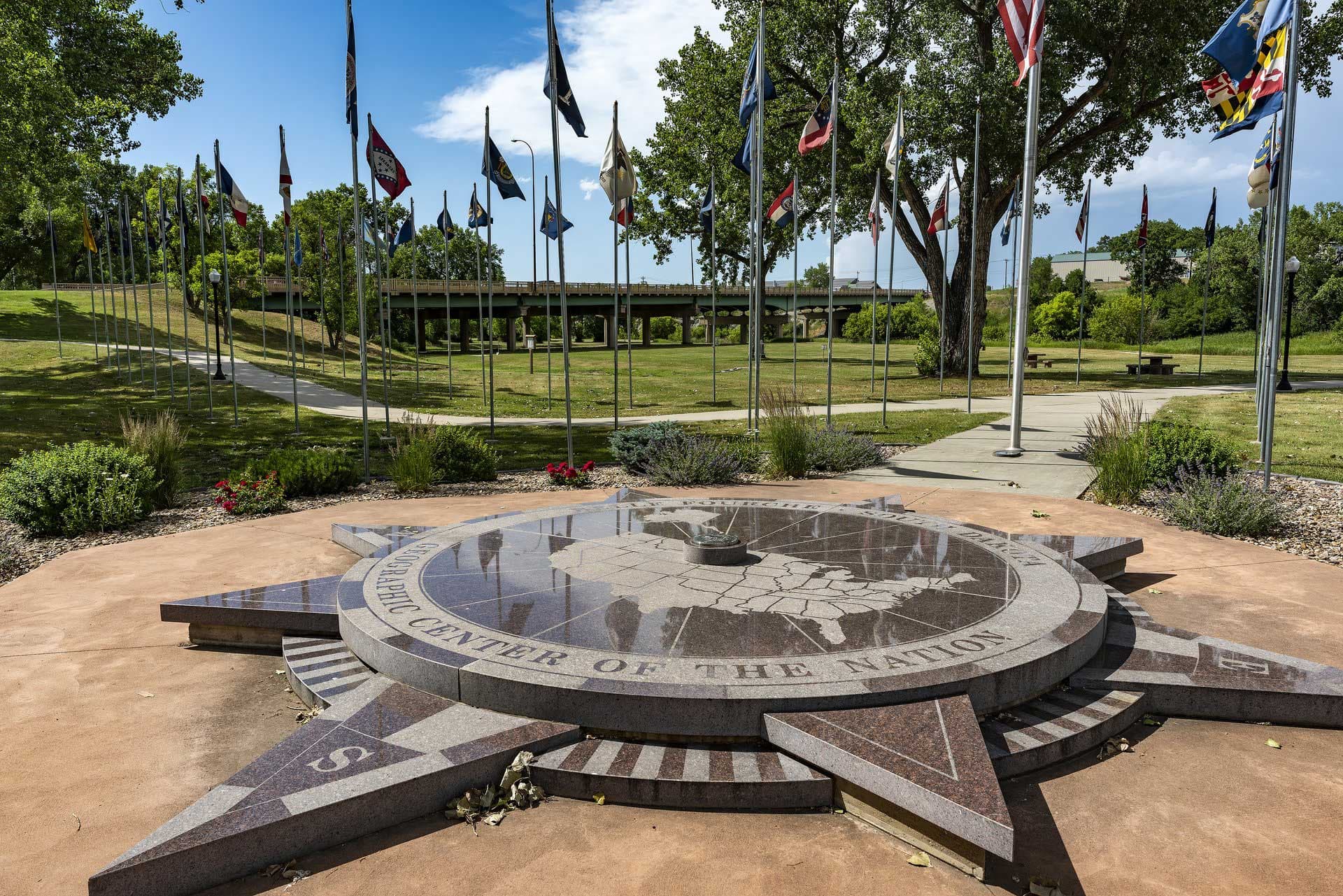 The Geographic Center of the Nation Monument is flanked by U.S. flags in Belle Fourche, SD.