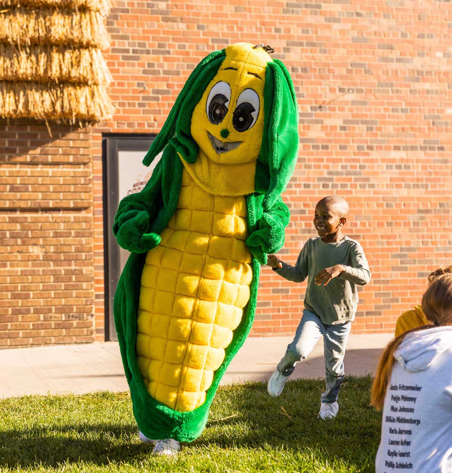 Tariq the "Corn Kid" dancing with a Corn Mascot