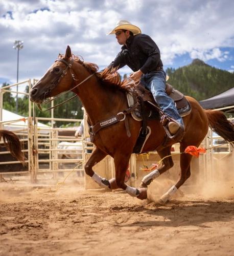 a cowboy rides on horseback at a rodeo in South Dakota.