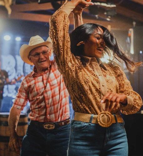 A bargoer in a cowboy hat twirls a woman on the dance floor of Saloon No. 10 in Deadwood, South Dakota.