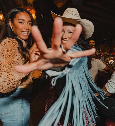 A woman reaches toward the camera as she dances with her friend at Saloon No. 10 in Deadwood, South Dakota.