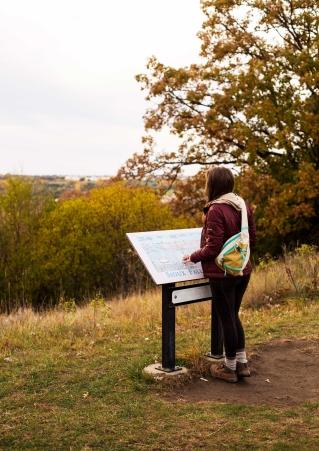 Woman at trail map in fall