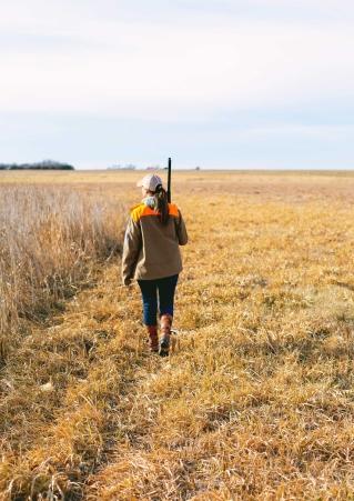 Pheasant hunter walking in field