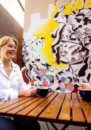 A person enjoys coffee in front of art in the patio area of M.B. Haskett Delicatessen in Sioux Falls