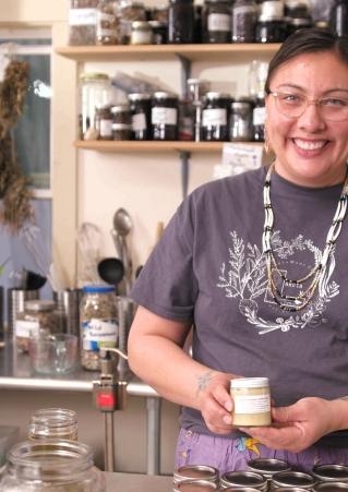 An Indigenous woman poses with her traditional homemade medicines