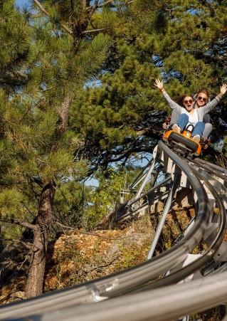 A couple rides a mountain coaster at Rush Mountain Adventure Park. Keystone, South Dakota.