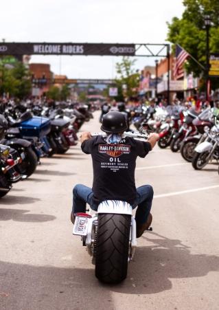 Man on a motorcycle riding into downtown Sturgis for the annual Motorcycle Rally.