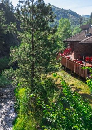 A building with wraparound patio overlooks a rushing creek at Deadwood Gulch Gaming Resort in Deadwood, South Dakota.