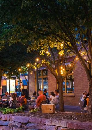 People drinking on a patio under string lights at Fernson Downtown, a brewery in Sioux Falls, South Dakota.