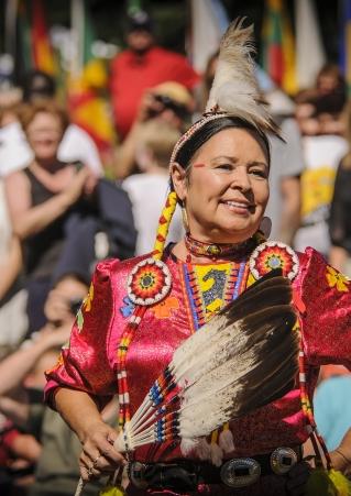 Native American woman carries feathers