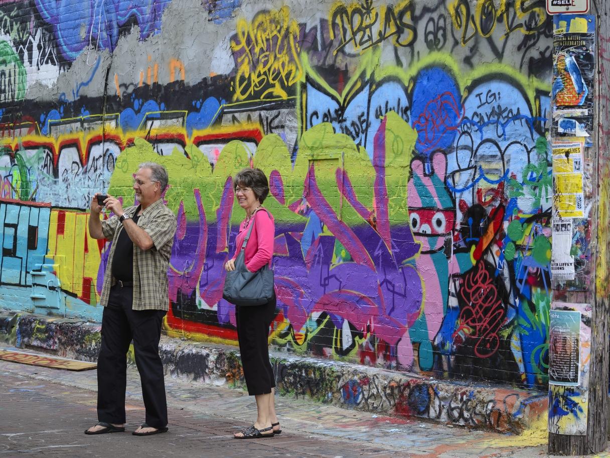 Tourists take photos of the walls in Art Alley.