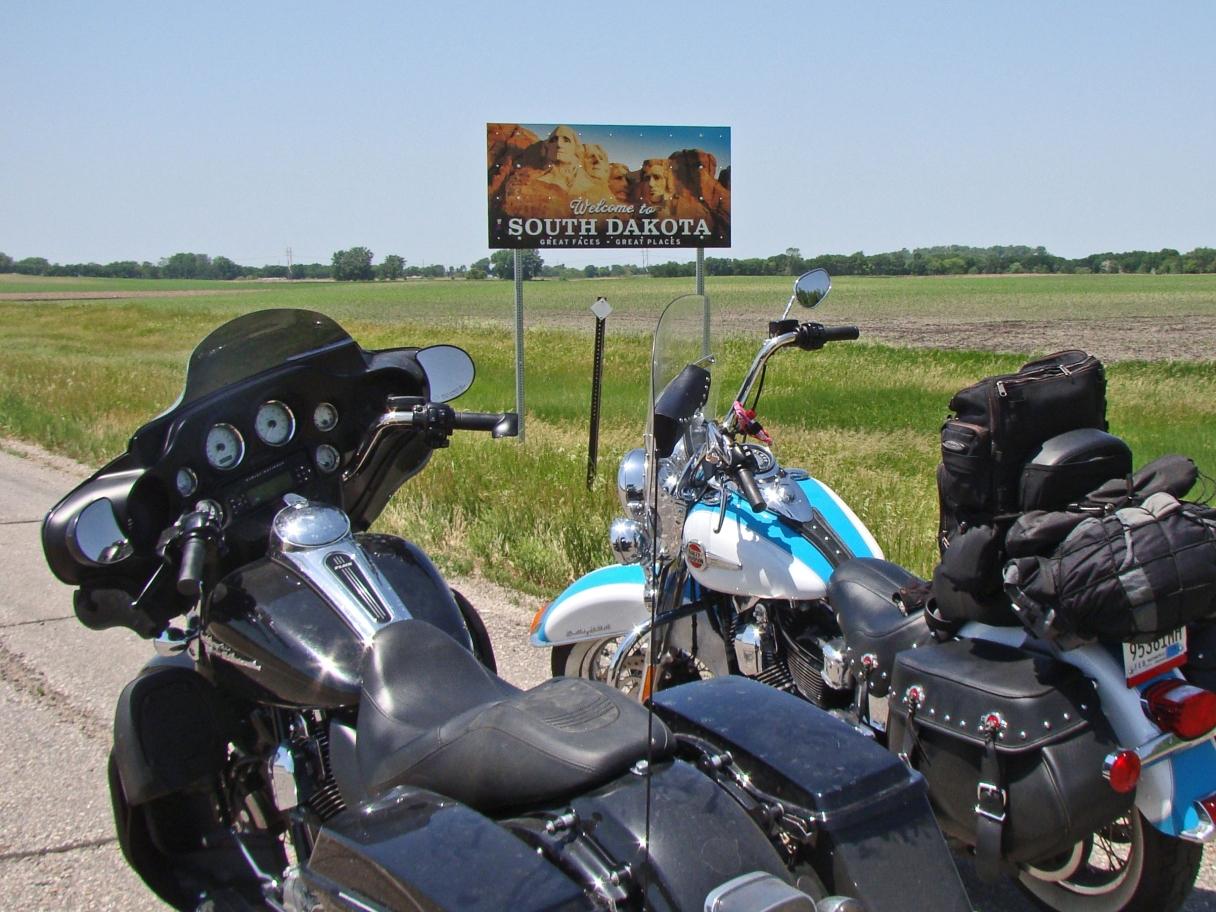 Motorcycles in front of the South Dakota state sign