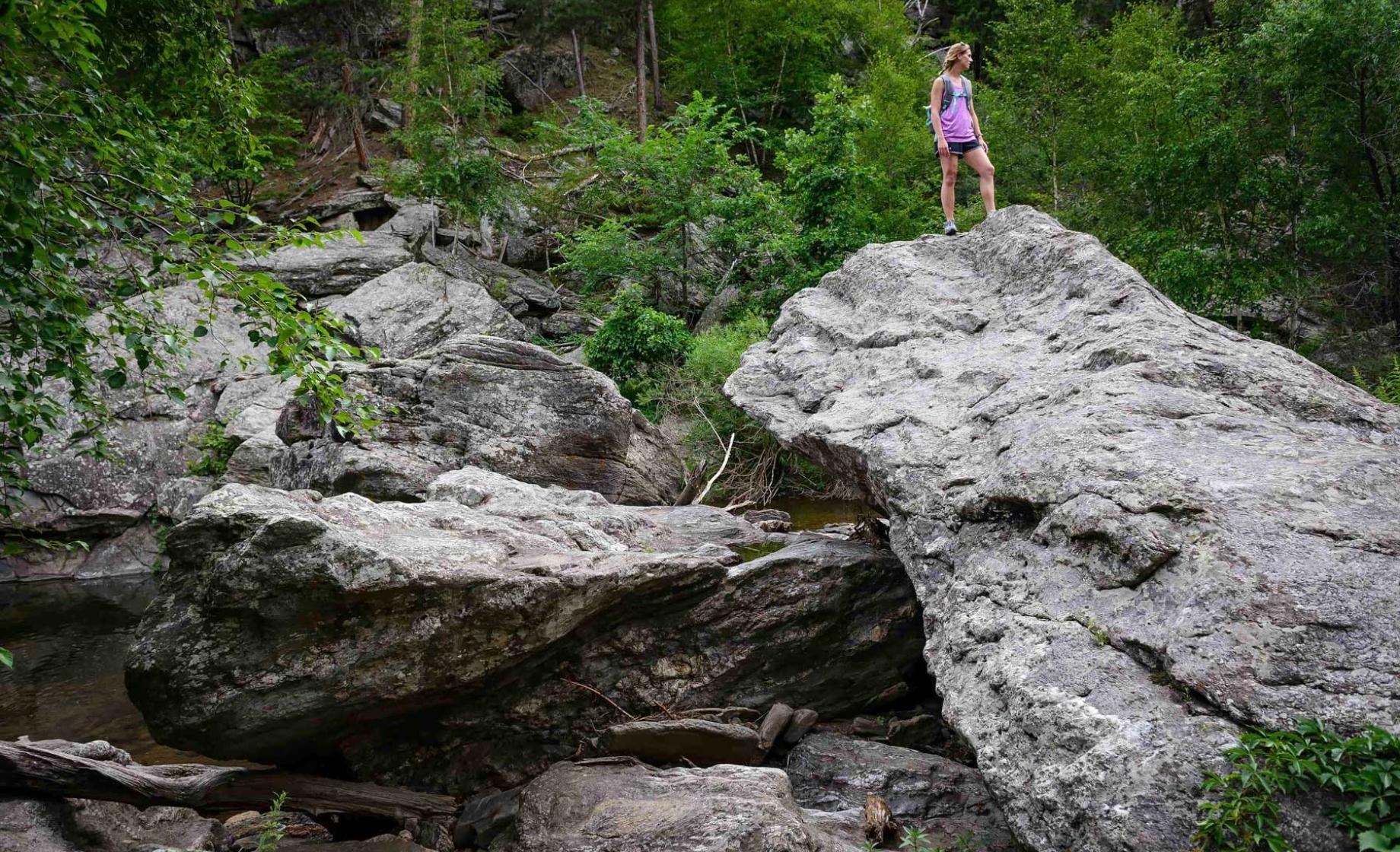 Hiker on large rock in Black Elk Wilderness