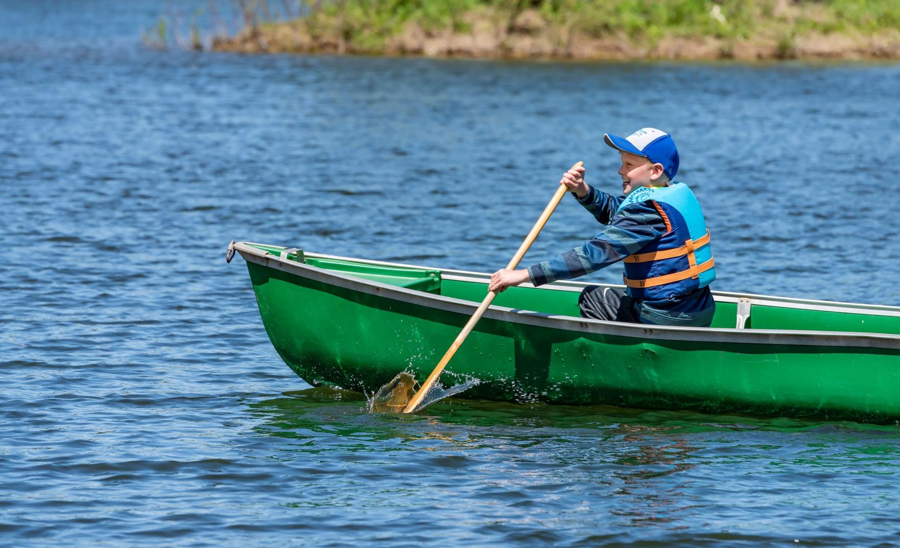 Boy paddles in a canoe near Watertown