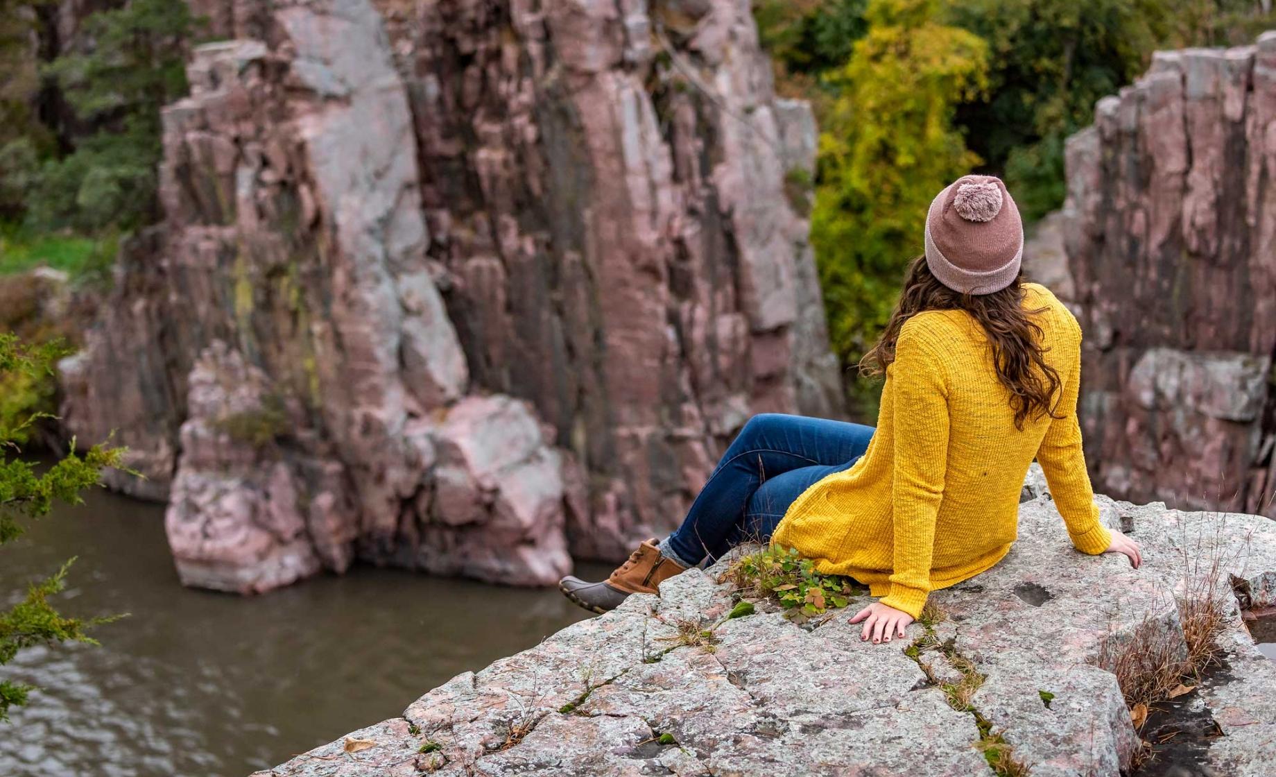 Woman sitting on river overlook in fall