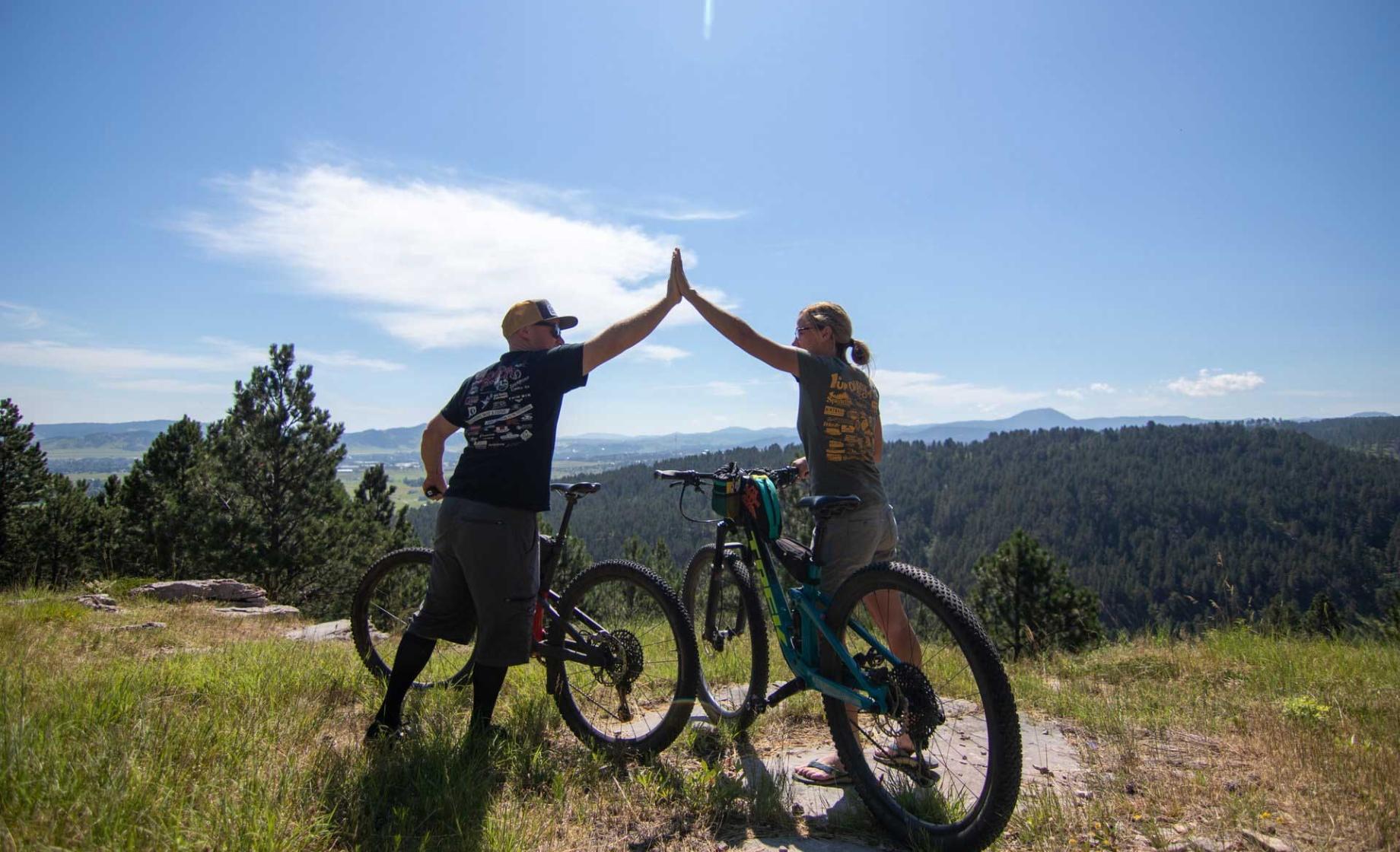 Man and woman mountain bikers hi-fiving