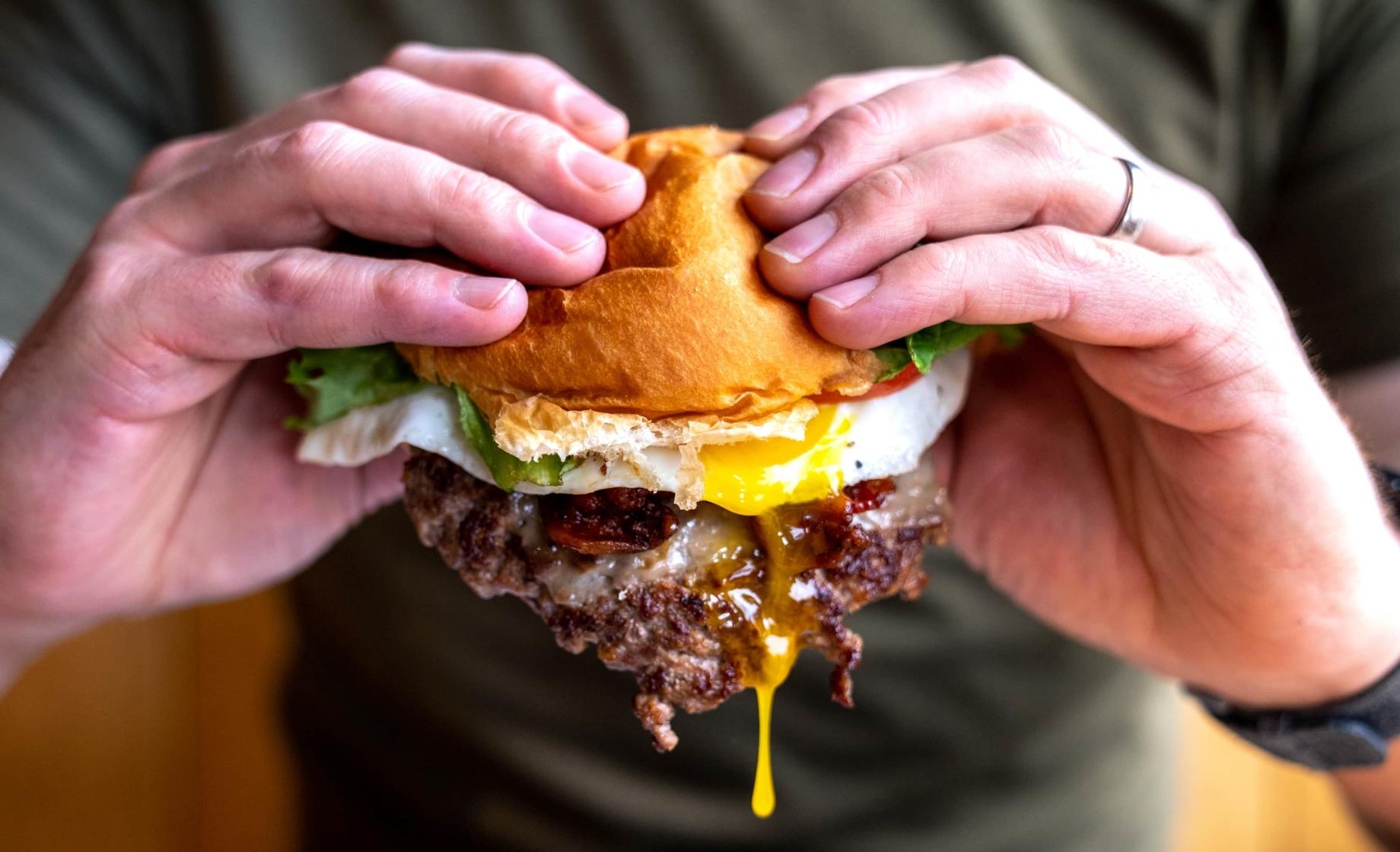 Black Hills Burger and Bun burger with yolk drip