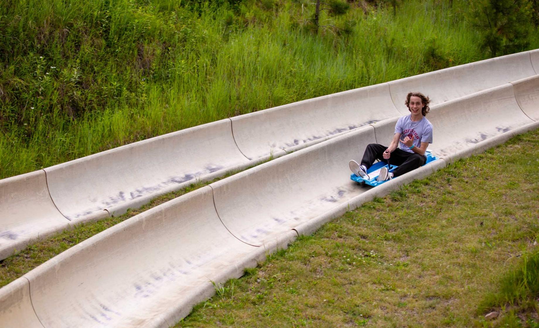 Kid on a large metal slide at Rushmore Tramway