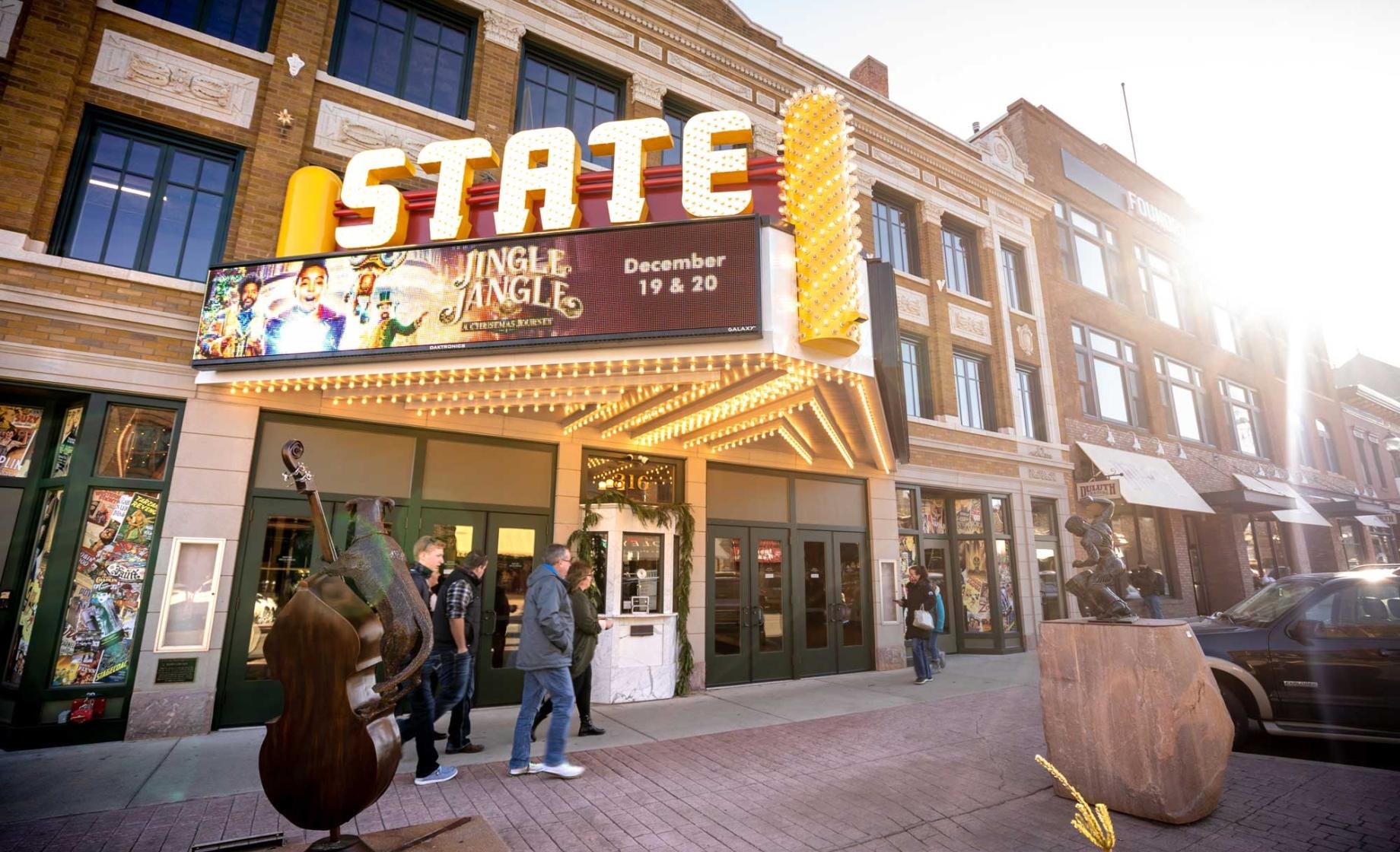 People in winter clothing walking past the State Theater