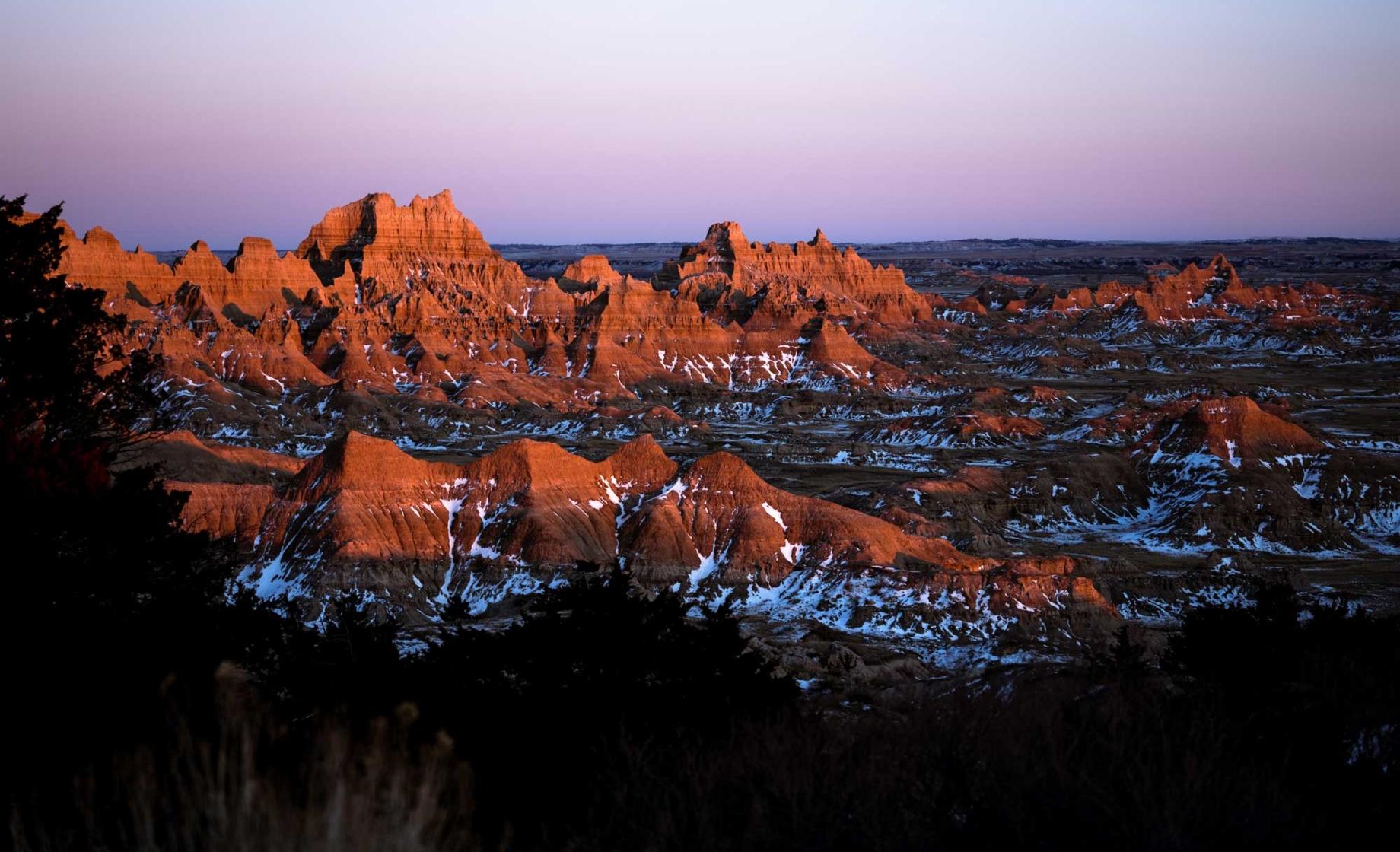 Badlands National Park rock formations covered in snow at dusk