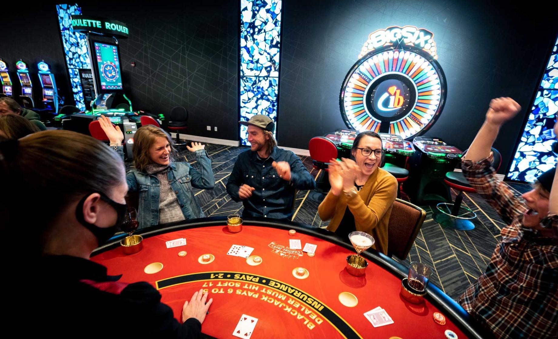 A group of people celebrate around a gaming table at a casino in Deadwood, South Dakota.