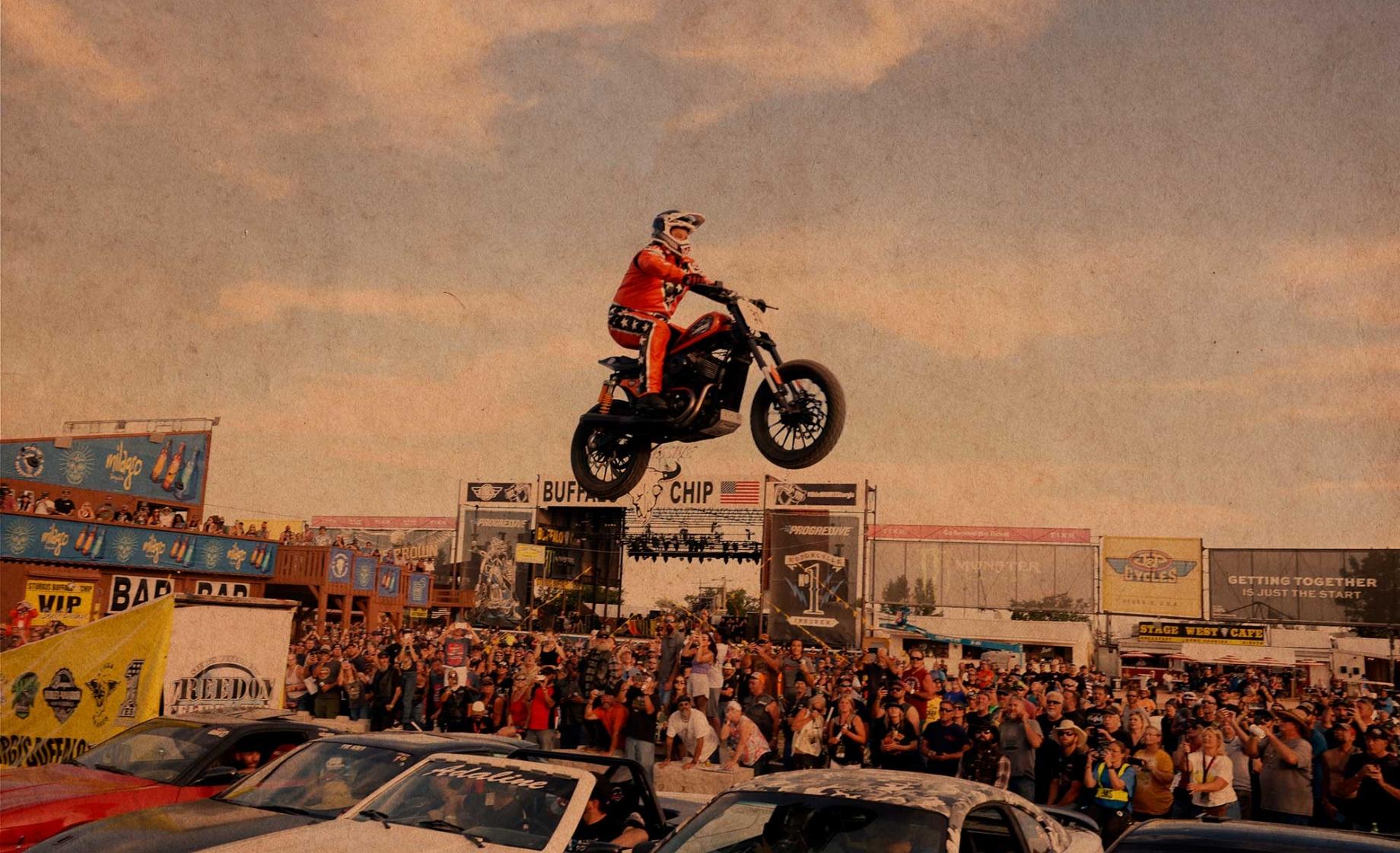 A motorcycle soars over a line of cars during an event at the Sturgis Motorcycle Rally. Sturgis, SD.