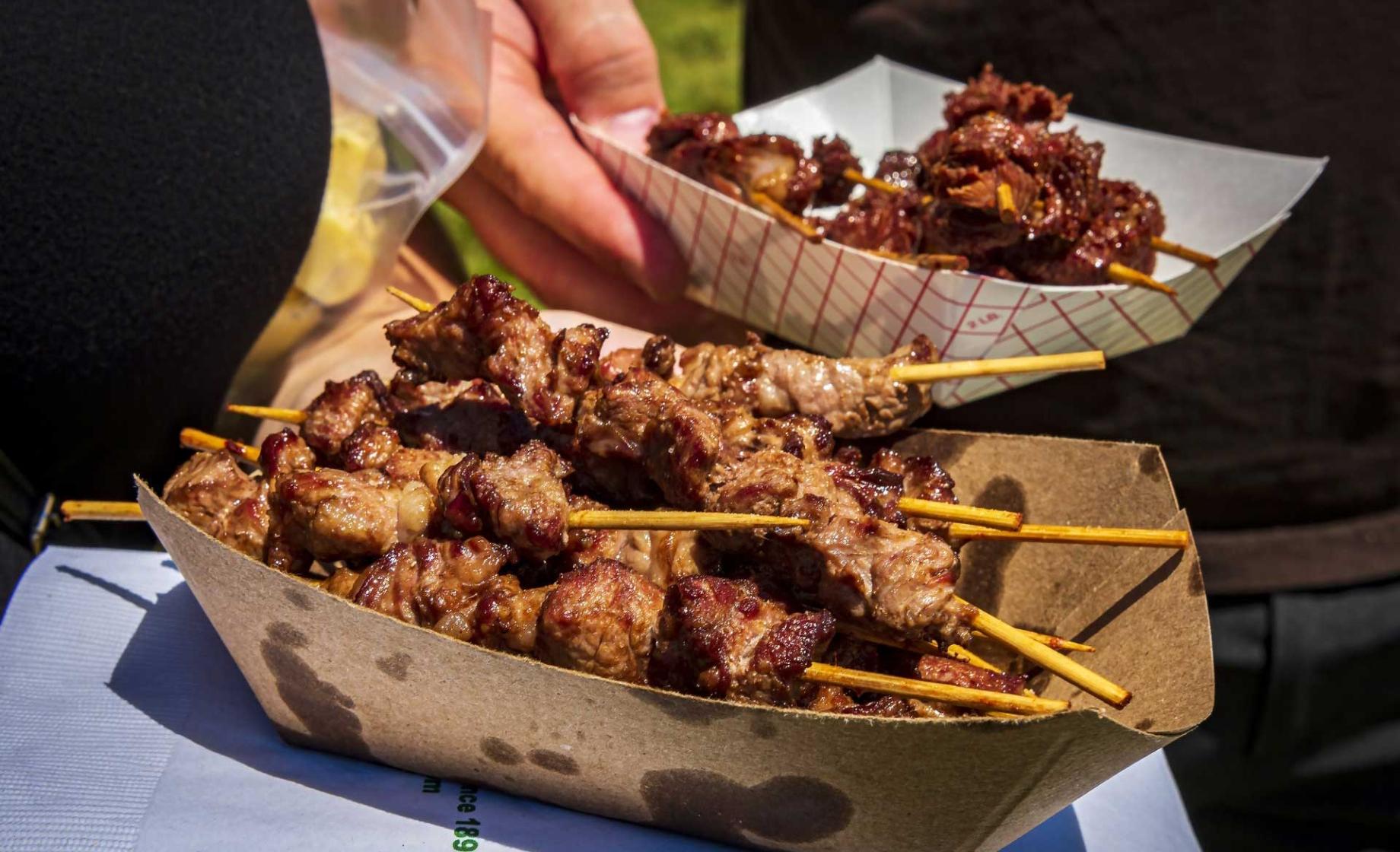 Close up of two containers of chislic, a South Dakota culinary specialty consisting of chunks of meat on skewers. South Dakota Chislic Festival, Freeman, SD.