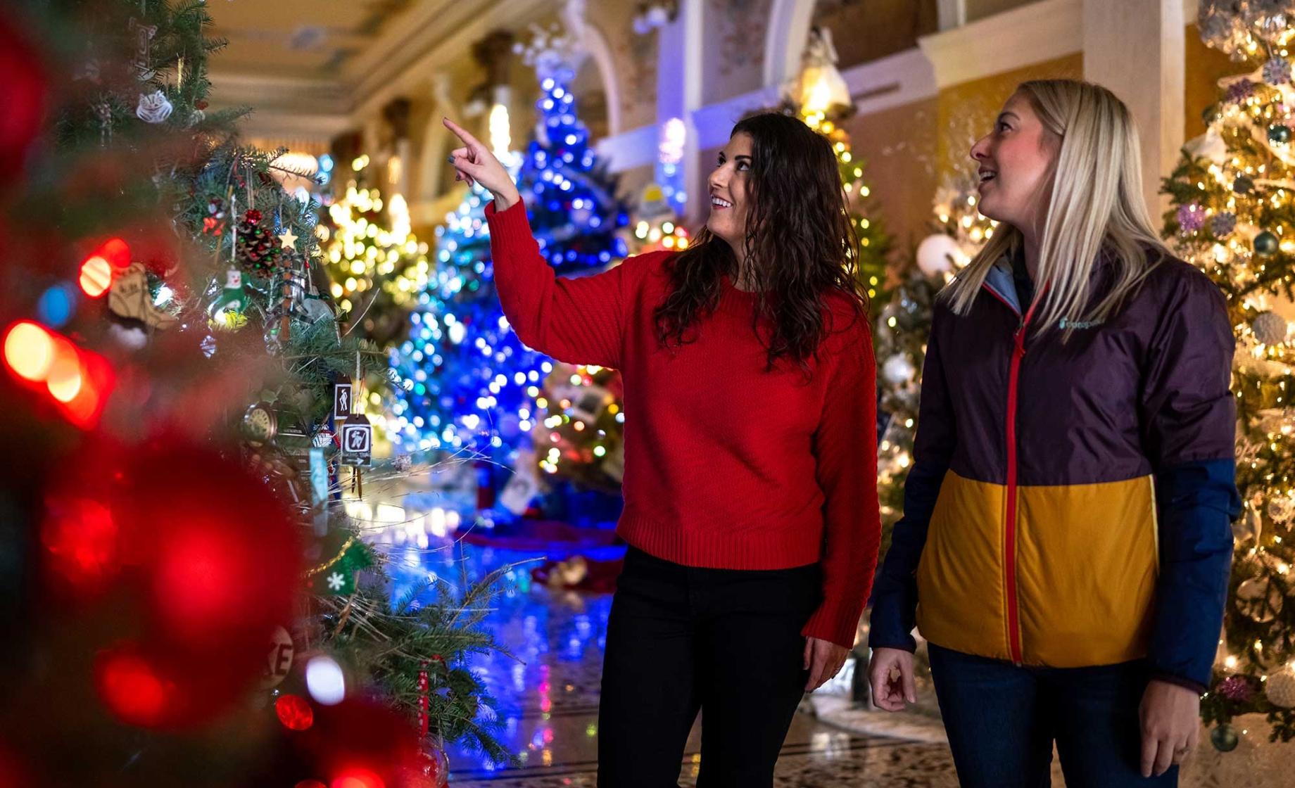 Two women admire colorfully decorated holiday trees at Christmas at the Capitol in Pierre, South Dakota.