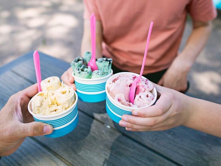 Family holding three cups of rolled ice cream