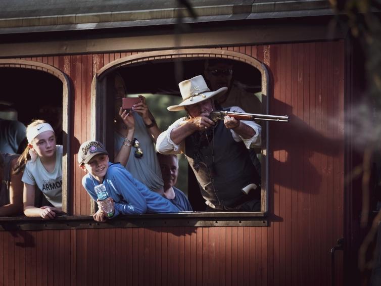 An actor aims his rifle out of the window of the 1880 Train in South Dakota.
