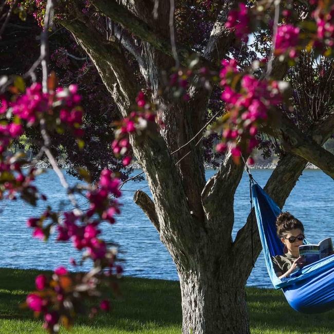 Girl in hammock in Pierre with bright trees (hero crop)