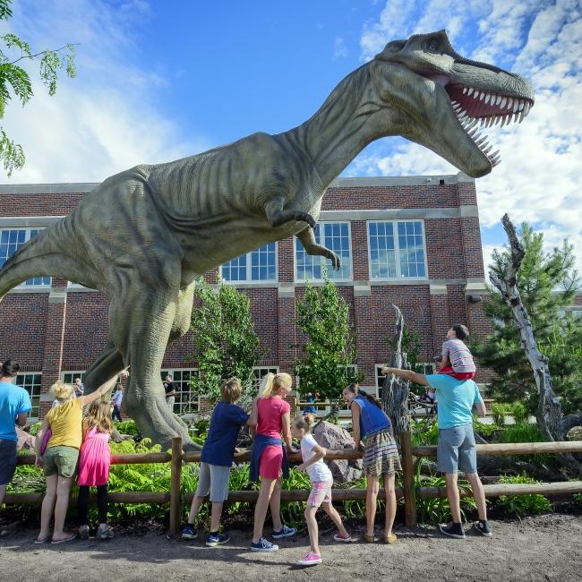 Visitors view the dinosaur outside of the Children's Museum.