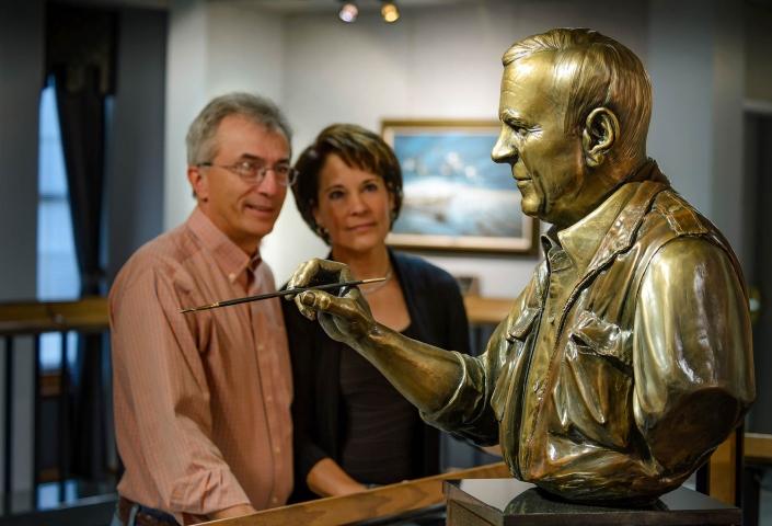Couple viewing sculpture of a man painting