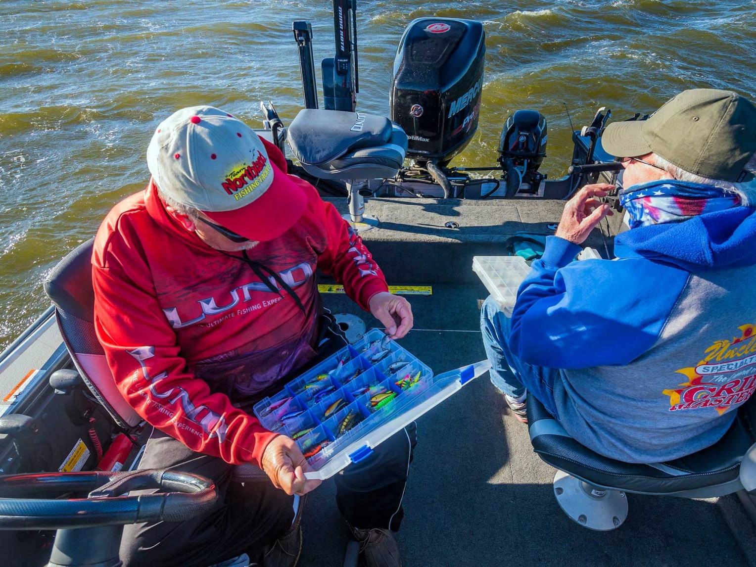 Men looking at fish tackle on boat