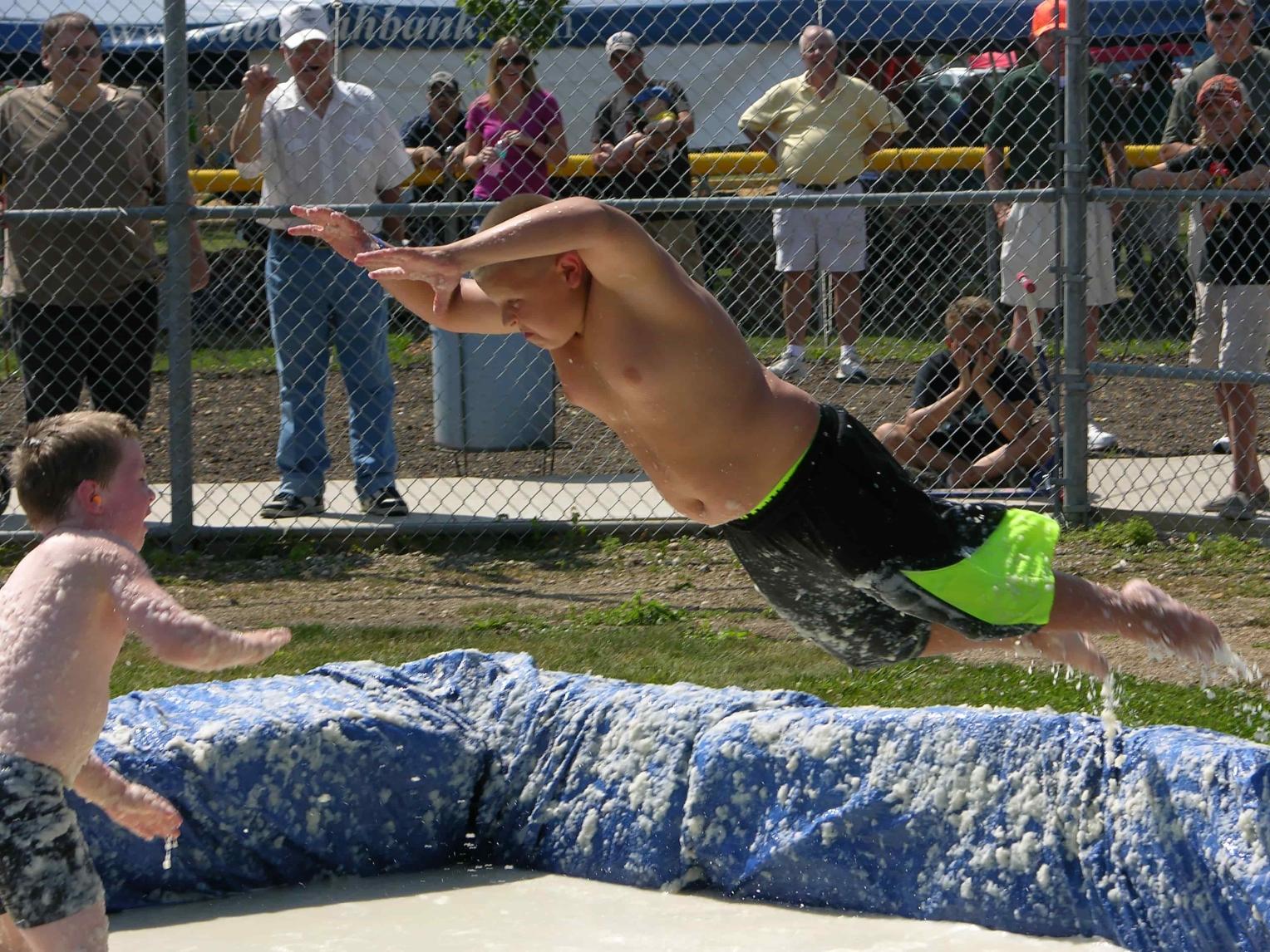 A boy launches against his opponent in a ring of mashed potatoes during Clark's Potato Days celebration