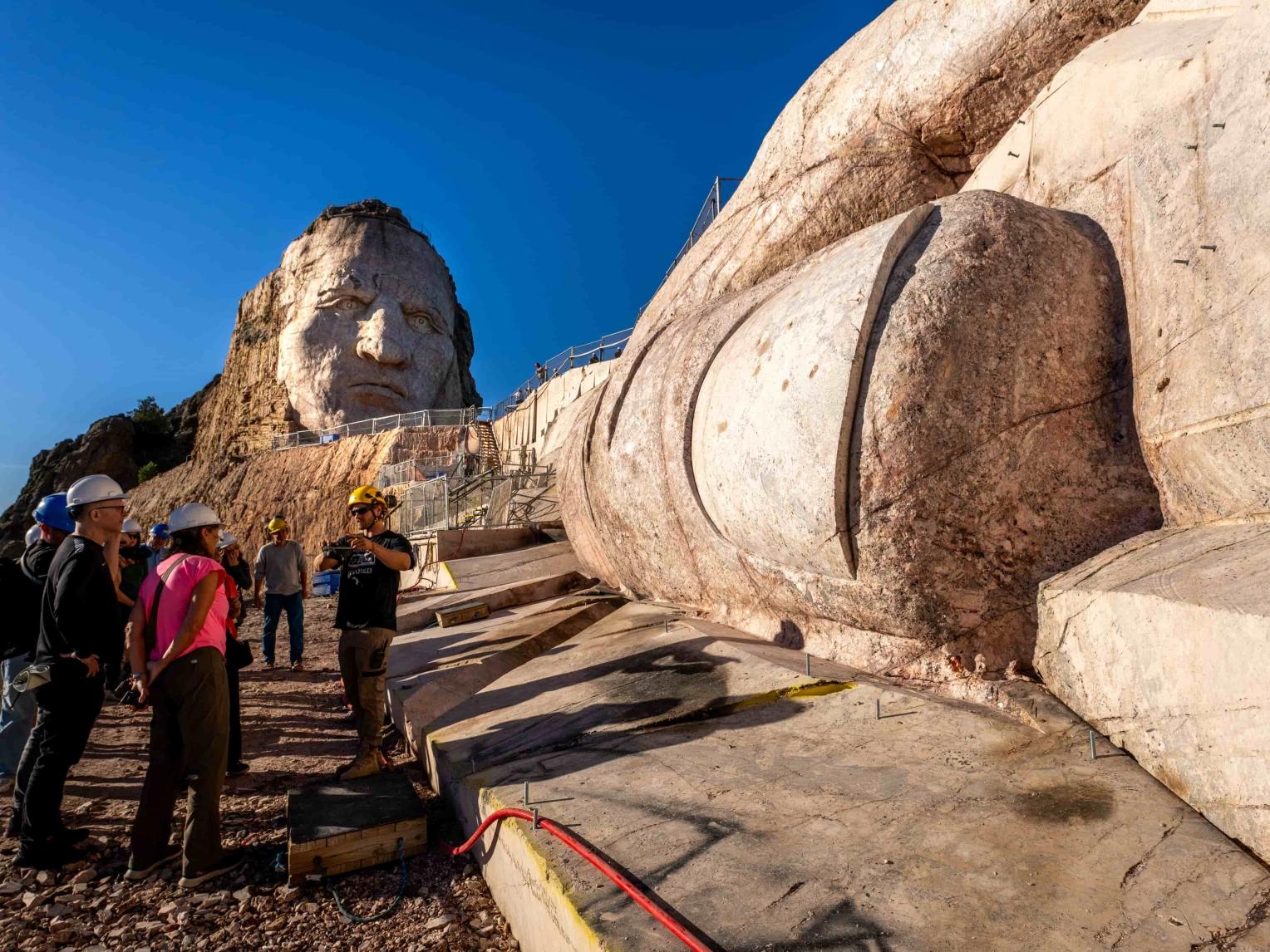 Observers look at the giant thumbnail and thumb of the Crazy Horse sculpture