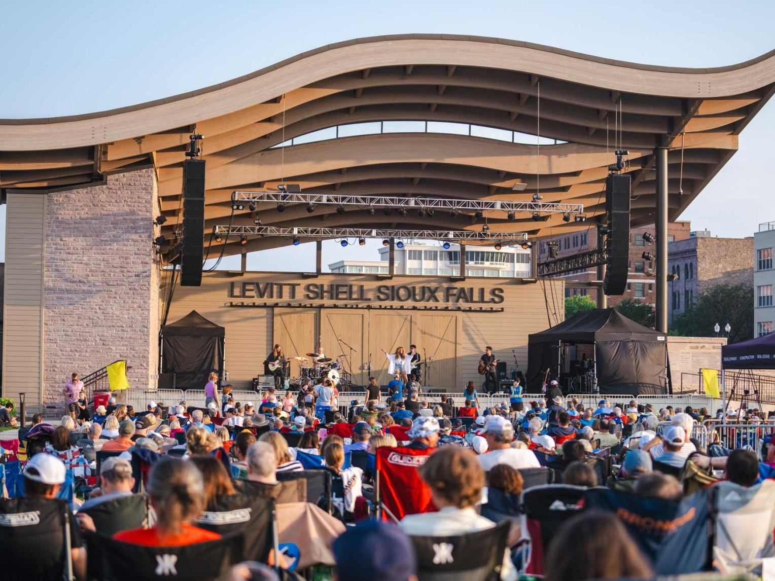 A crowd of people watch a concert at the Levitt Shell in Falls Park, South Dakota.
