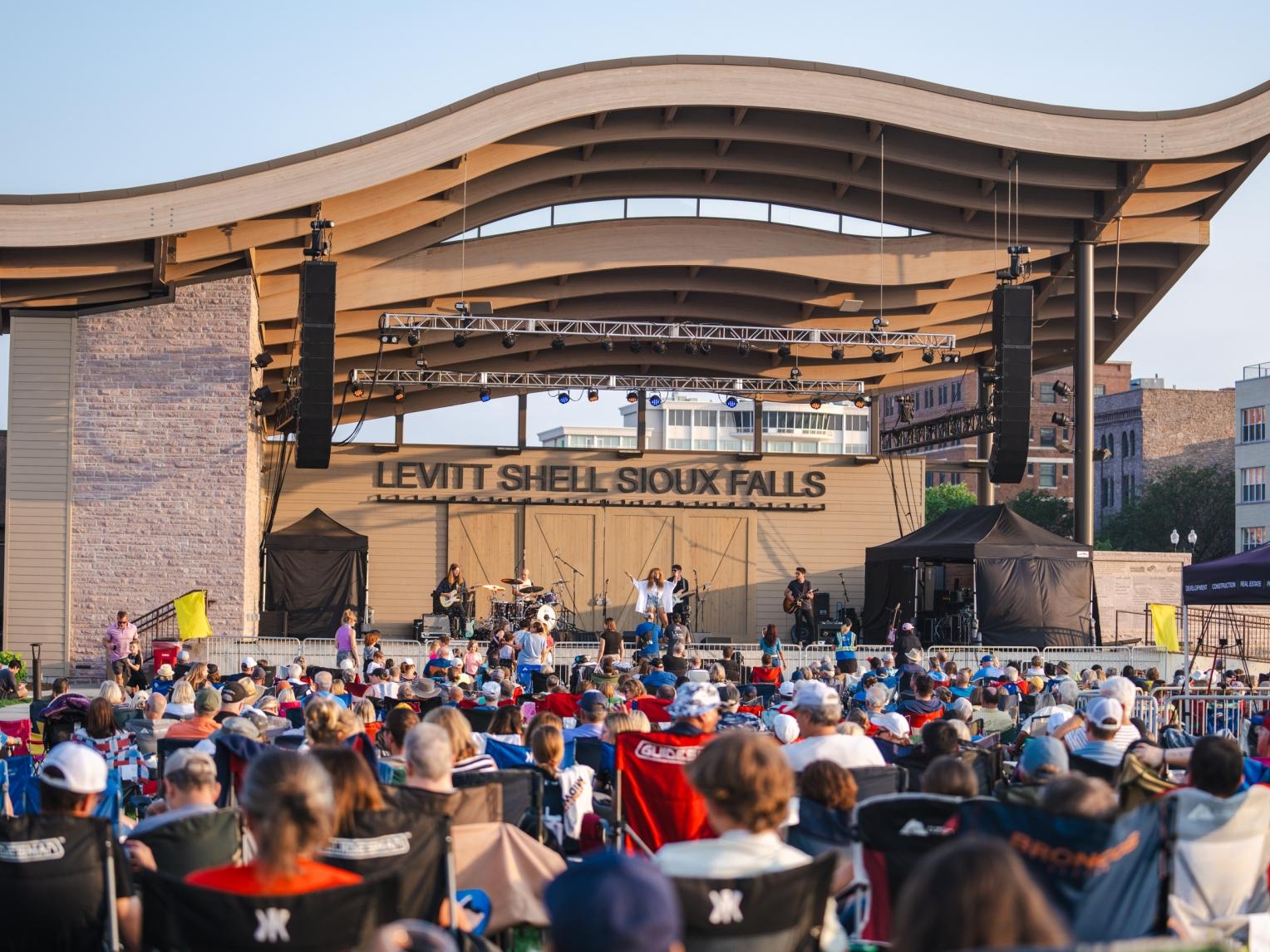 A crowd of people watch a concert at the Levitt Shell in Falls Park, South Dakota.
