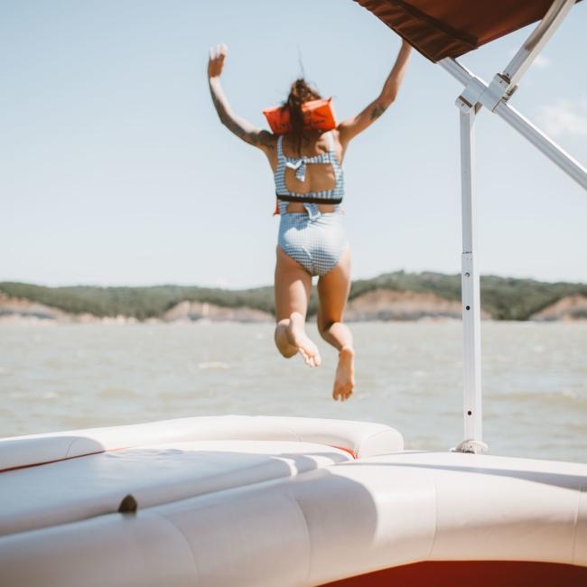 Little Girl jumping off boat into lake