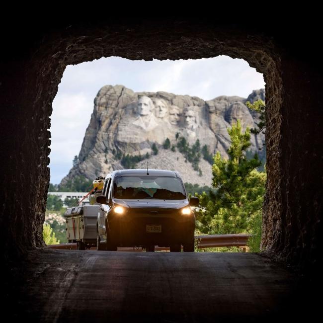 Cars driving away from Mount Rushmore through a tunnel
